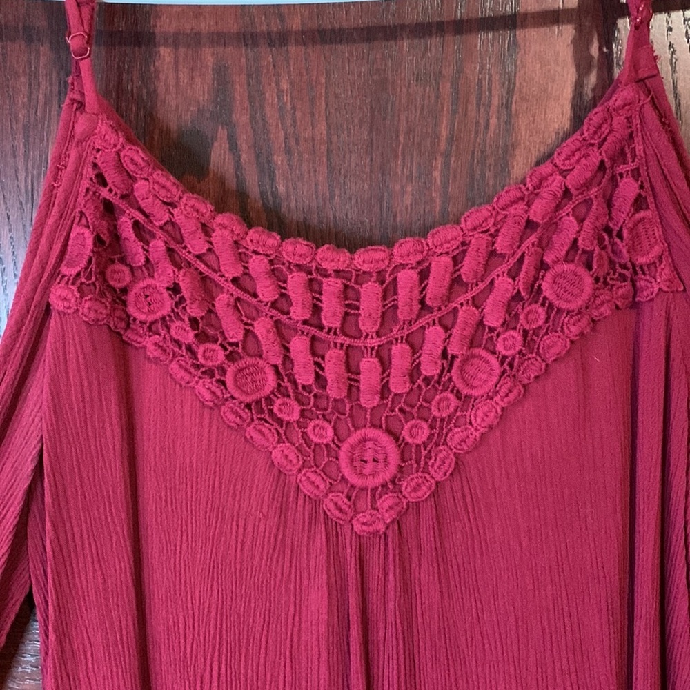 Flare long sleeve, peekaboo arms. Adjustable straps, lace design on front.